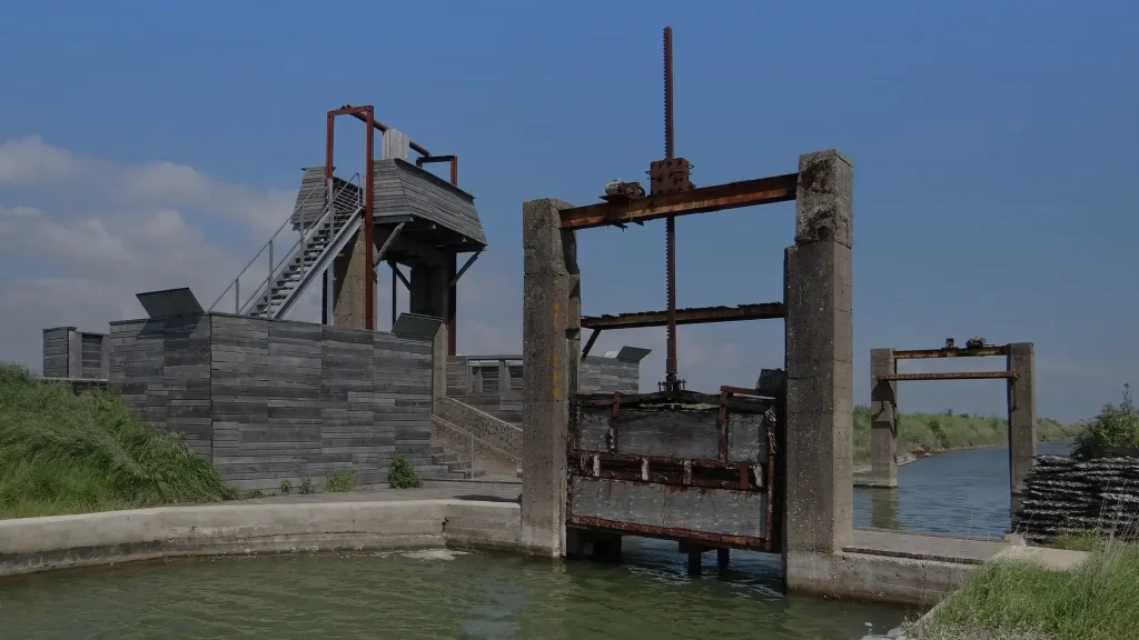 Vanne rouillée et poste d'observation en bois au bord des bassins de la pointe d'Arçay, à La Faute-sur-Mer en Vendée