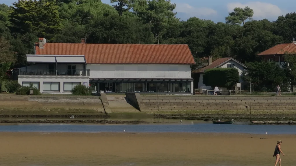 Le lac d'Hossegor à marée basse, villas et pins en fond