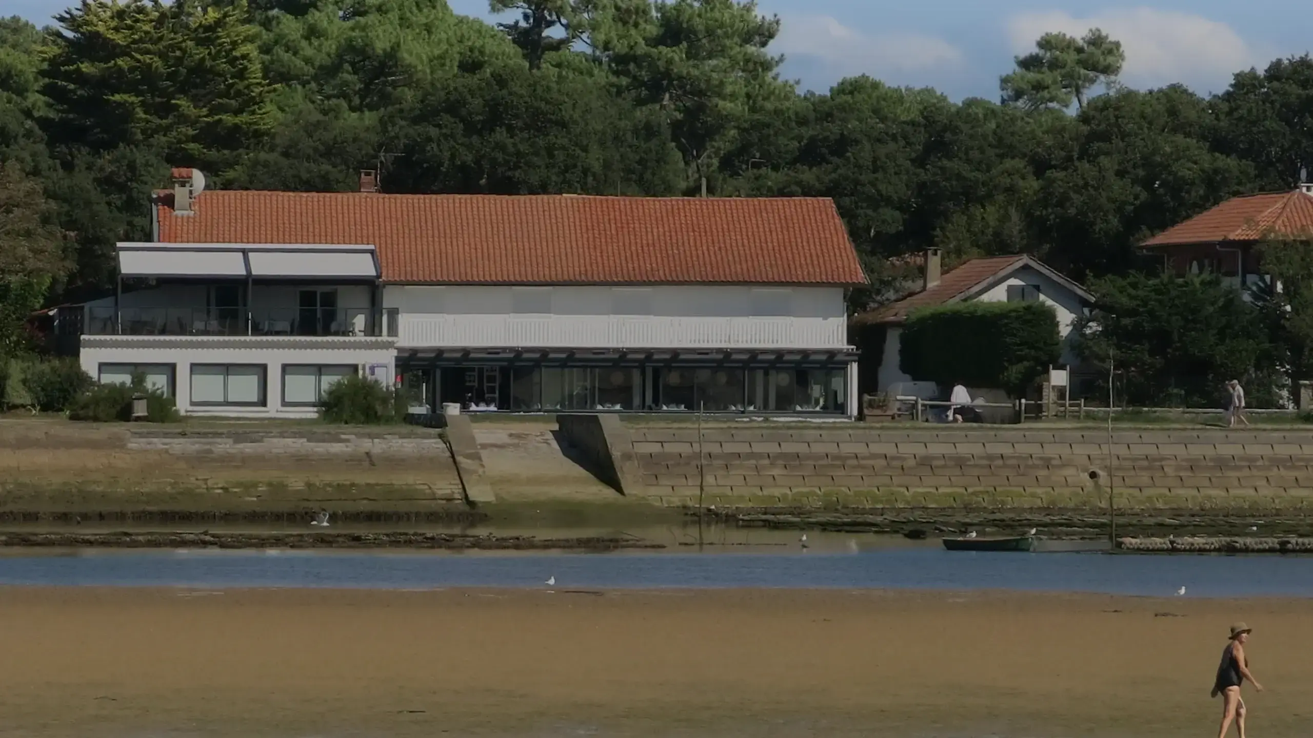 Le lac d'Hossegor à marée basse, villas et pins en fond