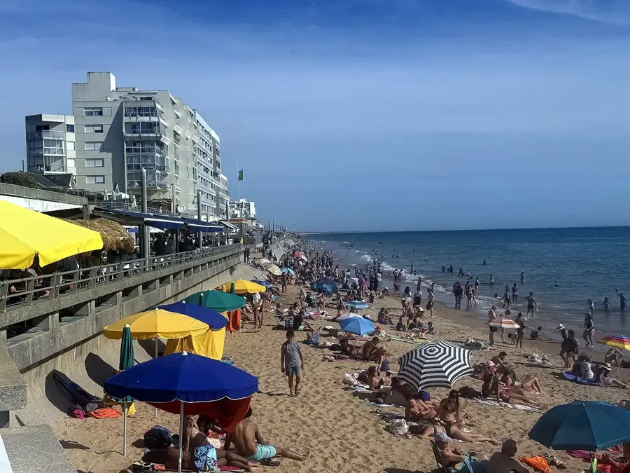 La Grande Plage de Saint-Gilles-Croix-de-Vie en août, avec parasols, remblai et immeubles en front de mer