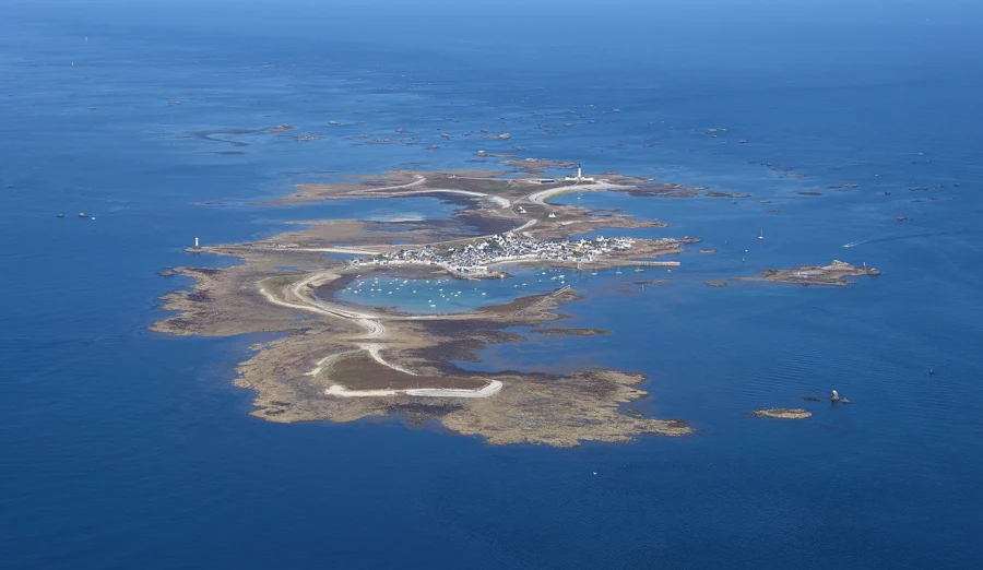 Vue aérienne de l'île de Sein, son village et son port, entourés de récifs